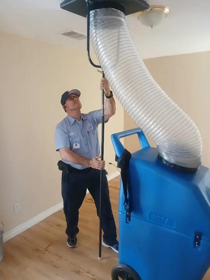 Furnace Tune-Up technician using HEPA equipment in Lantana